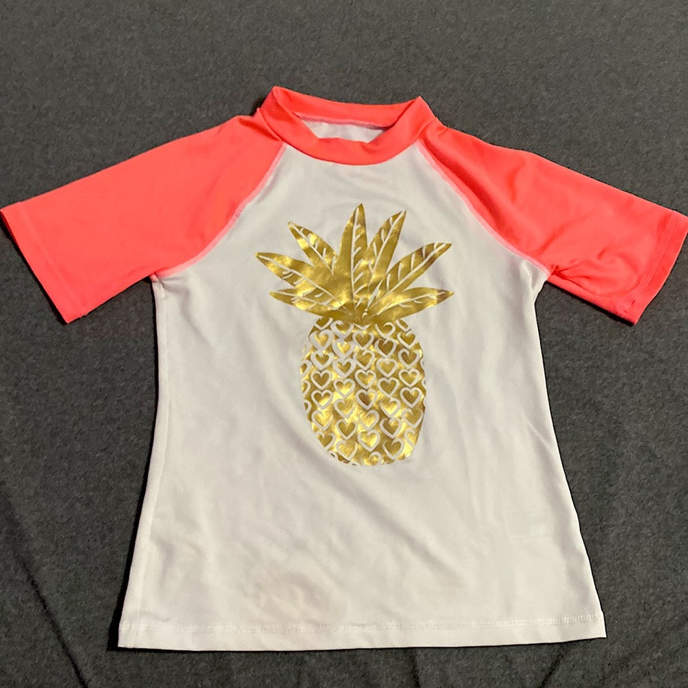White and Pink swim shirt with a pineapple on the front of it